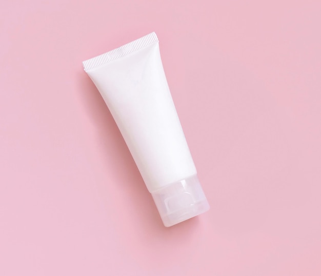 White cream tube on light pink top view Cosmetic Mockup Skincare product