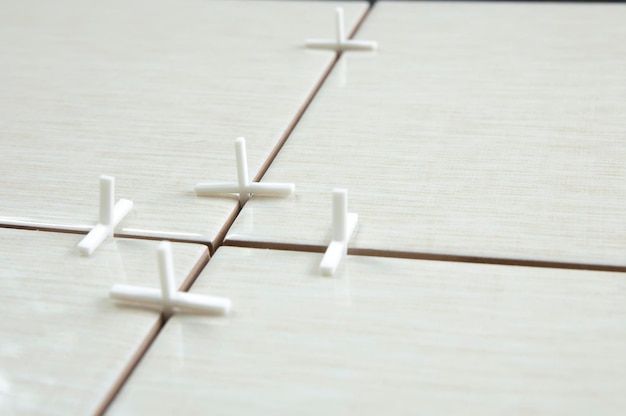 White crosses in the joints of tiles, tile laying repair concept