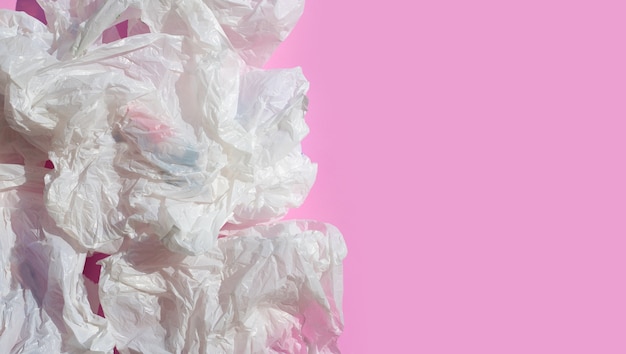 White crumpled plastic bags on pink surface