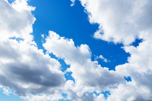 White cumulus clouds against blue sky, heavenly background.