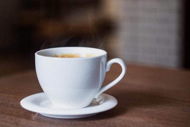 White cup of aromatic coffee on a wooden table