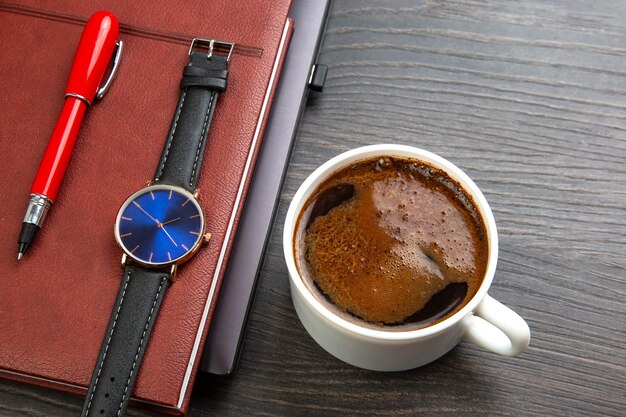 white cup of black coffee on the office table next to the laptop and business items