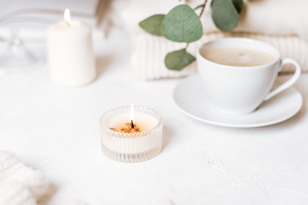 White cup of coffee, cotton, candles.