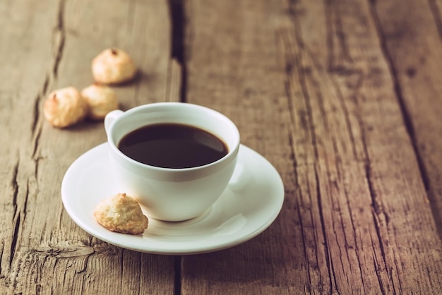 White Cup of Coffee and Homemade Coconut Cookies on Old Wooden Background Horizontal Copy Space