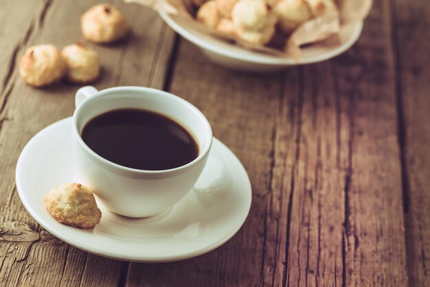 White Cup of Coffee and Homemade Coconut Cookies on Old Wooden Background Horizontal Copy Space