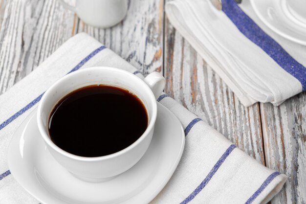 White cup of coffee on wooden kitchen table