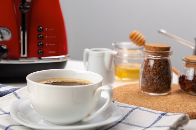 White cup of coffee on wooden kitchen table