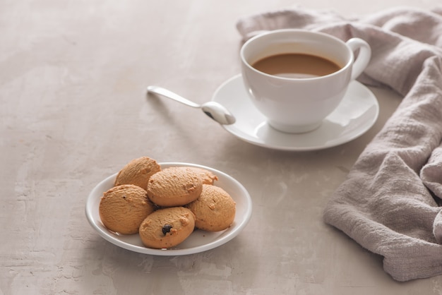 white cup of creamy coffee with butter cookies isolated on white background