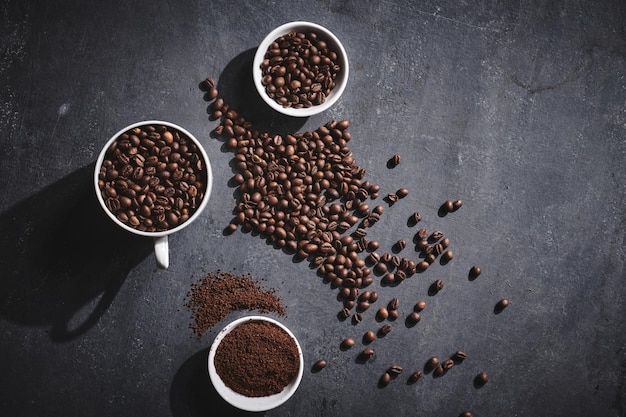 White cup of freshly brewed roasted coffee beans on gray background