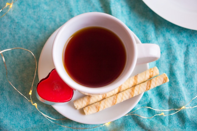 White cup with coffee or tea and a red heart