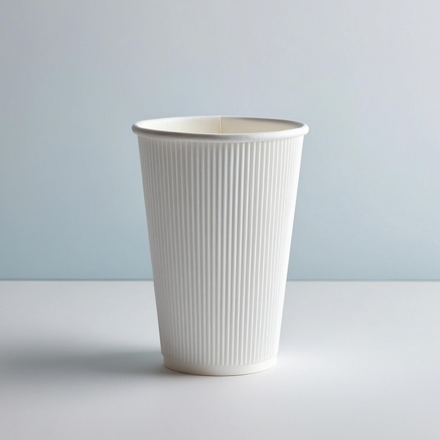 a white cup with a white design on it is on a table