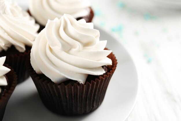 White cupcakes on wooden table