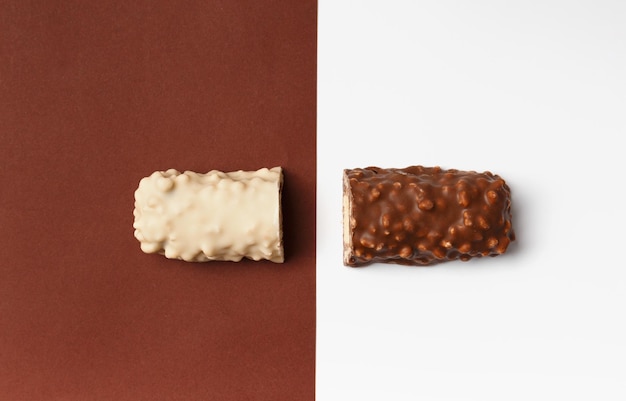 Photo white and dark chocolate on brown and white background top view conceptual representation of two opposites in the theme of chocolate two halves of a chocolate bar on a contrasting background