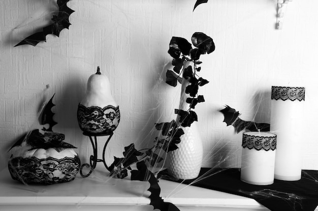 Photo white decorative fireplace with candles and white pumpkins