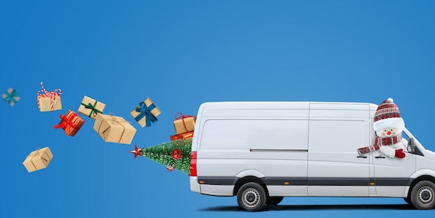 White delivery van driven by a snowman carries parcels and christmas presents on blue background. Space for text