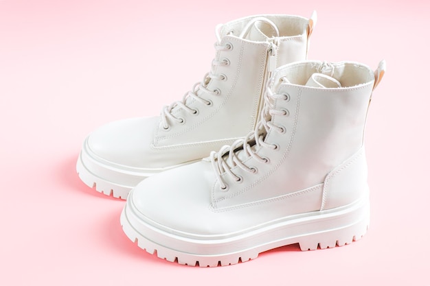 White demiseason martens boots made of ecoleather with a rough sole stand on a pink