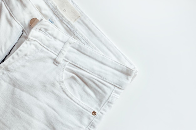 White denim pants on white background jeans closeup ripped denim