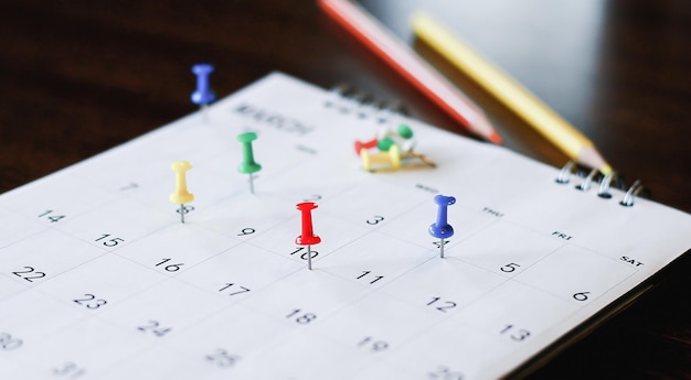 White desk calendar on dark wooden table planning concept