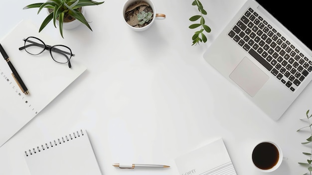 A white desk with a laptop coffee cup glasses and notebook