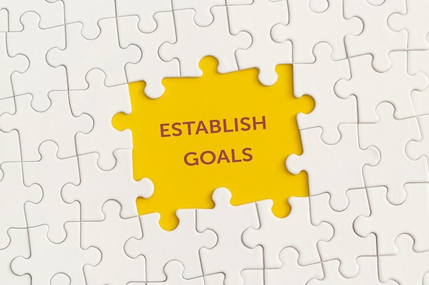 White details of puzzle with the text Establish goals on yellow background