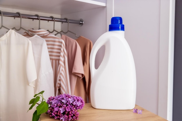 White detergent bottle mockup against the background of a wardrobe with clothes