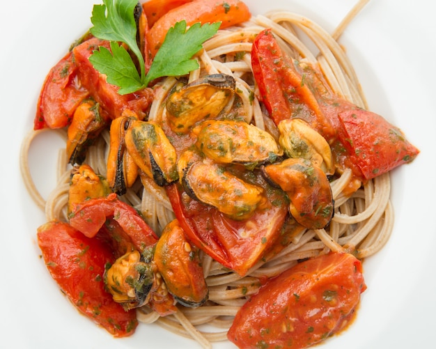 White dish with Pasta spaghetti , mussel and tomatoes