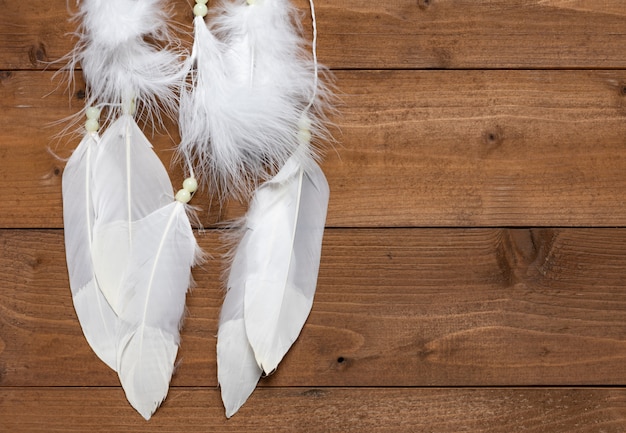 White dream catcher on wooden surface