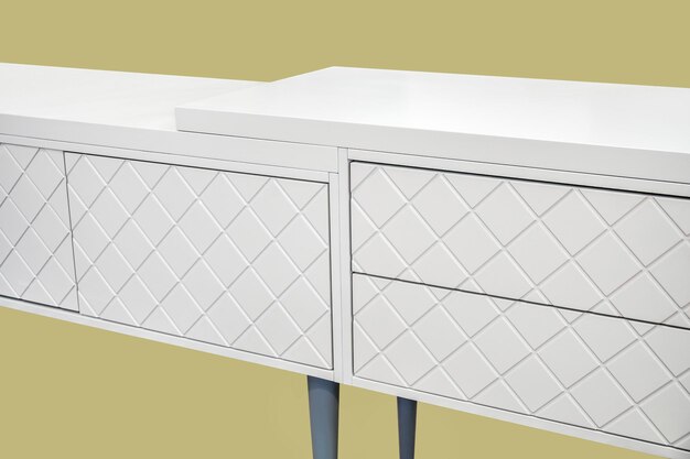 White dressing table with milled facades in shape of rhombs isolated on yellow background