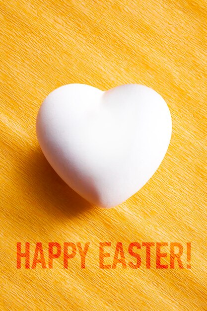 White egg in a heart shape with the words Happy Easter