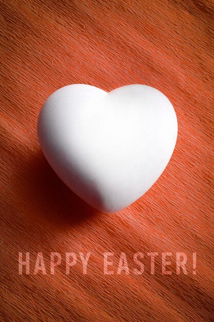 White egg in a heart shape with the words Happy Easter