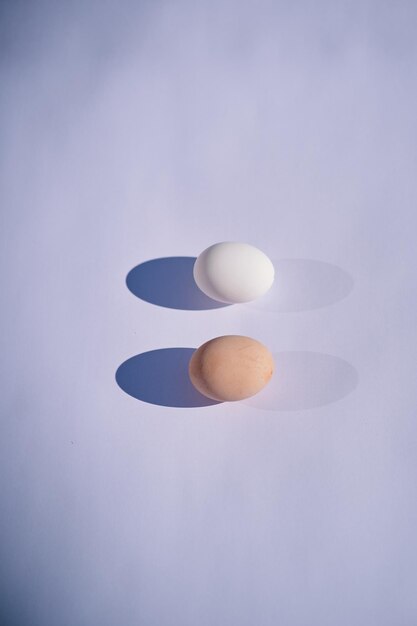 A white egg with a pink face sits on a gray surface.