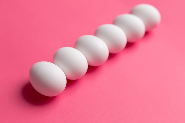 White eggs on a pink background