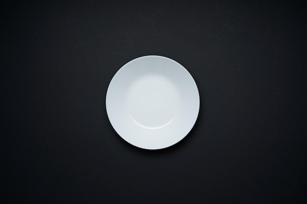 White empty disc plate isolated on black background . Flat lay and top view with copy space .