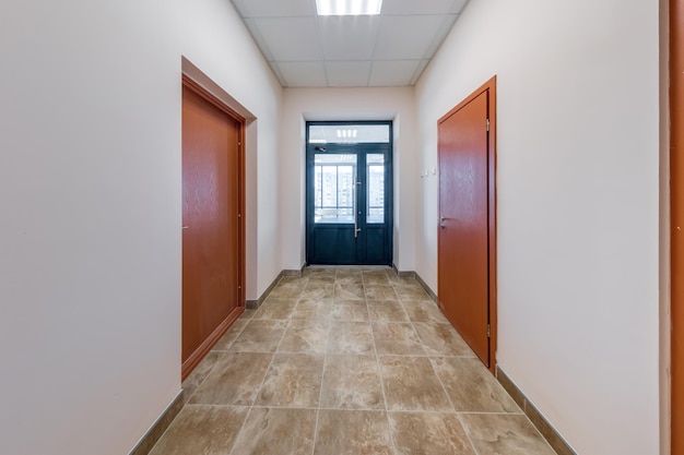 White empty long corridor with red brick walls in interior of modern apartments office or clinic