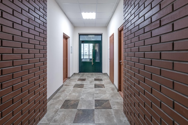 White empty long corridor with red brick walls for room office in interior of modern apartments office or clinic