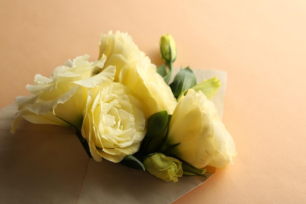 White eustoma in envelope on beige background