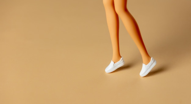 White female doll legs in white shoes