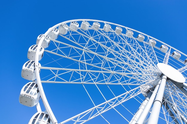 White ferris wheel against blue sky bottomup view