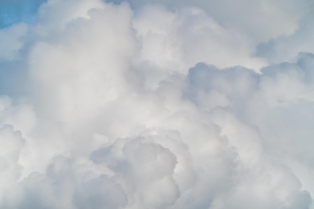 White fluffy clouds in a blue sky. Natural background and texture. White cumulus clouds