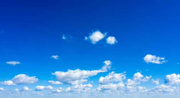 White fluffy clouds with rainbow in the blue sky