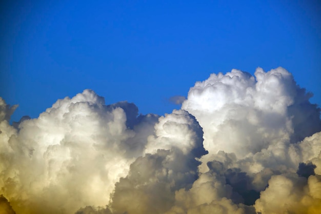 White fluffy cumulonimbus clouds forming before thunderstorm on summer blue sky Changing stormy cloudscape weather