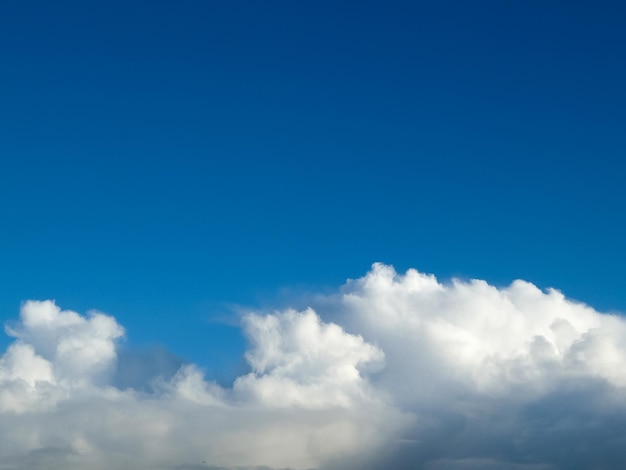 White fluffy cumulus clouds in the summer sky natural clouds background