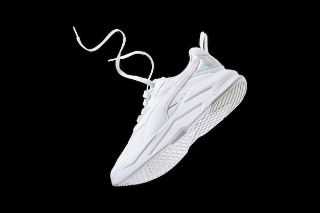 White flying sneakers isolated on black background