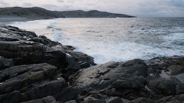 White foam waves run on the rocky shore of the white sea Nordic Barents Sea ocean