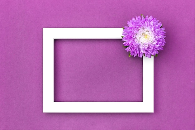 White frame decorated flower on purple background Copy space Mockup Top view Flat lay