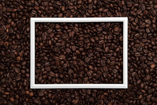 White frame on roasted coffee beans. Beautiful background. Copy space. Top view