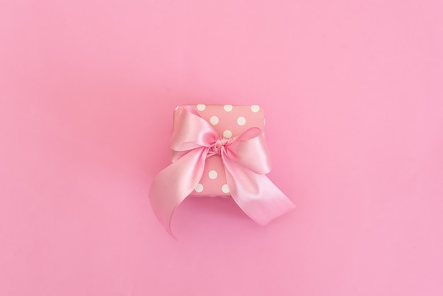 White Gift box with Blue ribbon on Pink background for copy space.