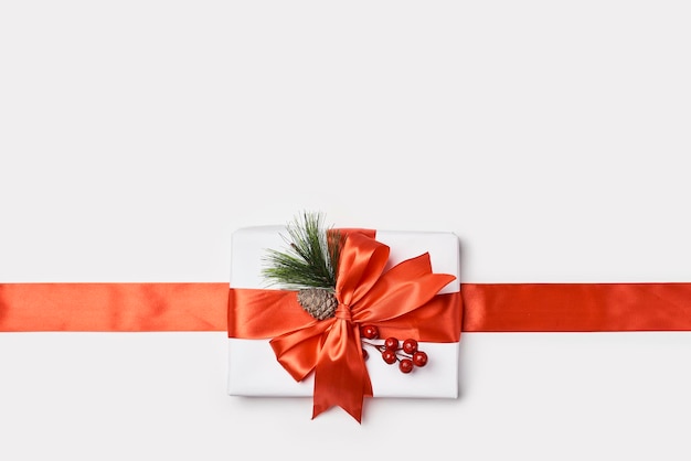 A white gift box with an orange ribbon and bow