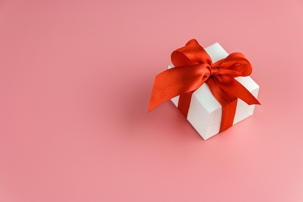 White gift box with red strap on colour , engagement ring box