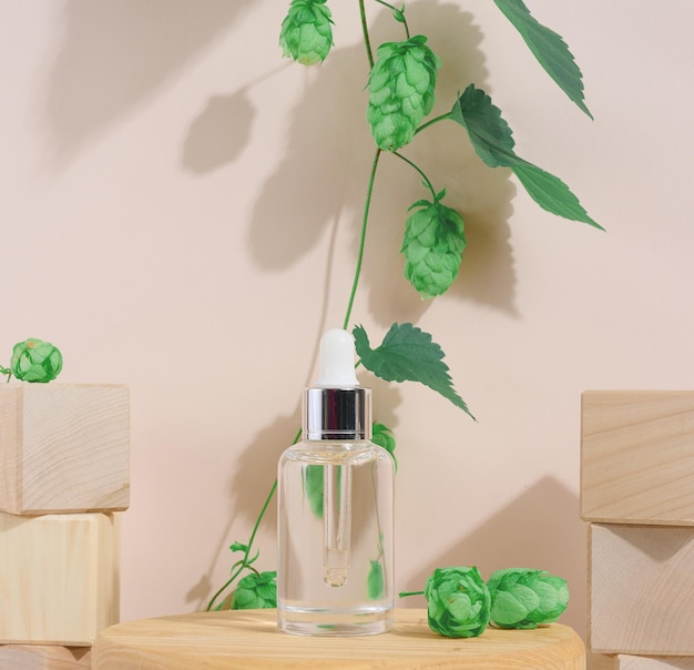 A white glass bottle with a pipette on a beige background Containers for cosmetics